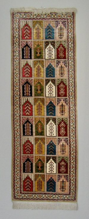 3152:: Oriental rug, Turkish ca.2007, silk, rectilinear, polychromatic, depicts mihrabs in series four across by nine, white fringe at ends. Dimensions:  21 x 60” Condition: Fine